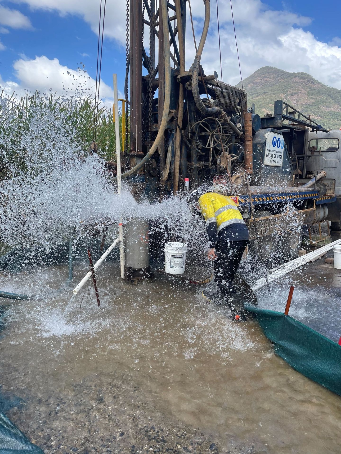 Water blowing from a bore beside the rig