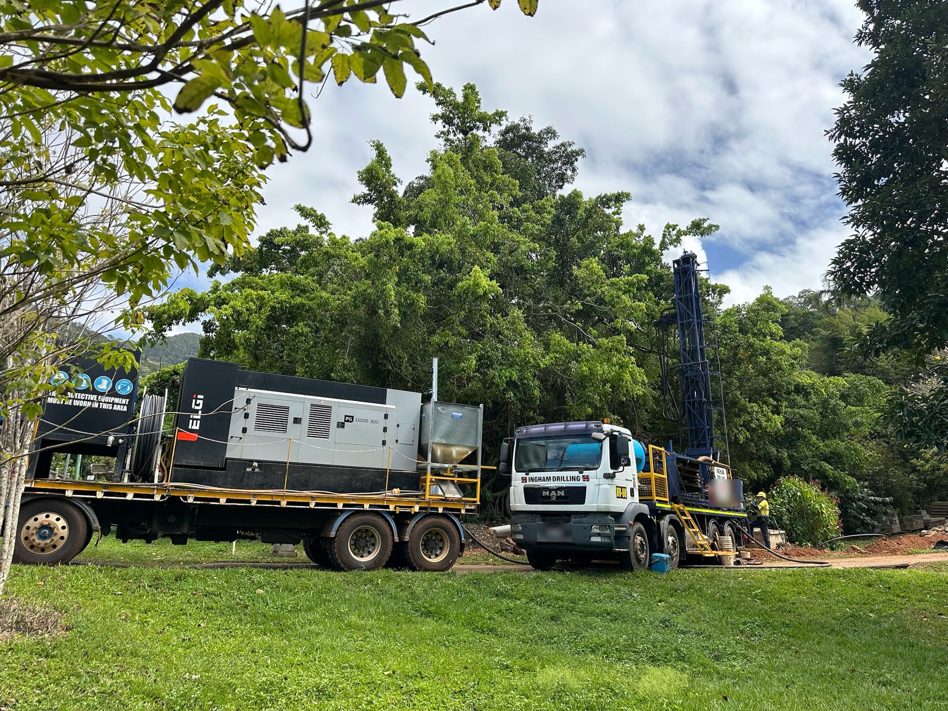 Rig HV-08 drilling beside rainforest, with the ELGi compressor truck parked in front