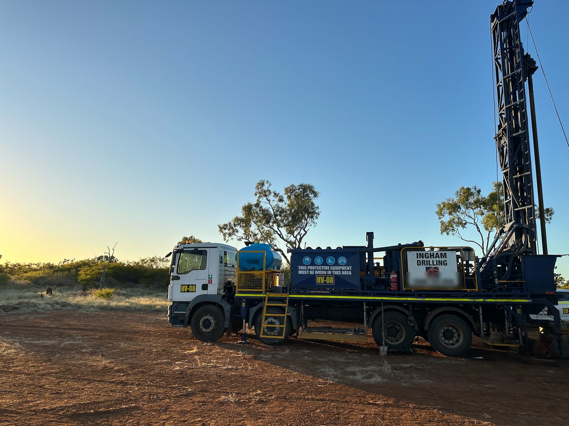 Mobile B80 rig HV-08 on a MAN truck, mast up at first light on red dirt